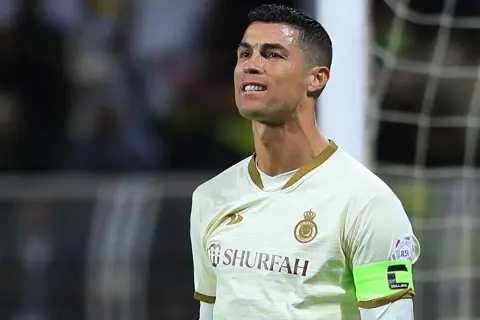 Cristiano Ronaldo, wielokrotny piłkarz roku FIFA, w białej koszulce z zieloną opaską kapitana.