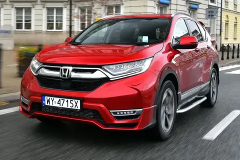 Czerwony Honda CRV 2024 jedzie ulicą.