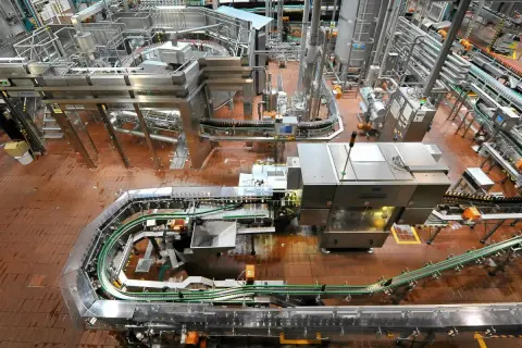 Widok z góry na linię produkcyjną browaru z butelkami na taśmociągach.
