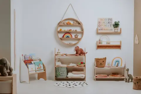 A serene nursery showcasing Montessori organization at home. Wooden shelves display books, toys, and soft blankets, creating a calm and inviting space for a child.