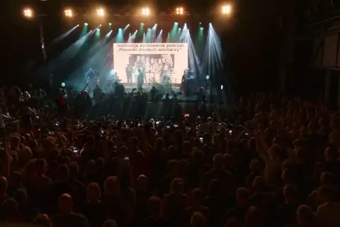 Koncertowy tłum, na ekranie tekst "Instrukcja zachowania podczas „Piosenki młodych wioślarzy”". To kult, gdy nie ma dzieci, tekst na ekranie.