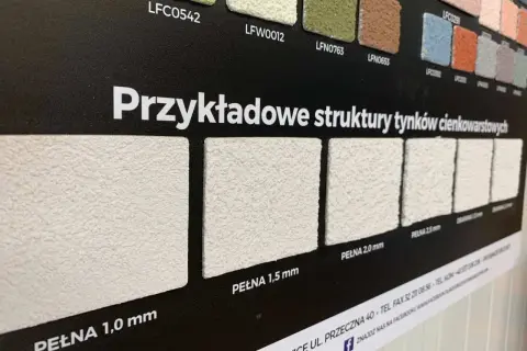 Próbki tynków elewacyjnych o różnych fakturach i grubościach ziarna.