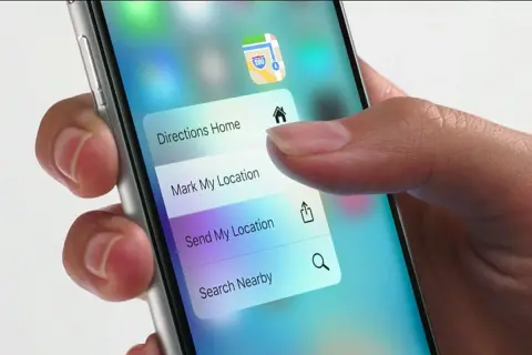 Dłoń naciska na ekran telefonu, aktywując menu z opcjami nawigacji. Funkcja 3D Touch pozwala na szybki dostęp do "Directions Home", "Mark My Location" i innych.