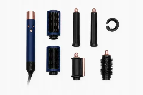 Niebieski styler do włosów Dyson z akcesoriami: szczotki, lokówki i okrągła końcówka.