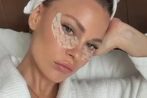 Mujer con parches en los ojos, luciendo relajada. Quizás se pregunta: ¿vitamina k para qué sirve?