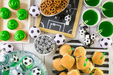 Idealne przekąski na mecz: zielone babeczki, mini burgery, napoje i piłkarskie gadżety.