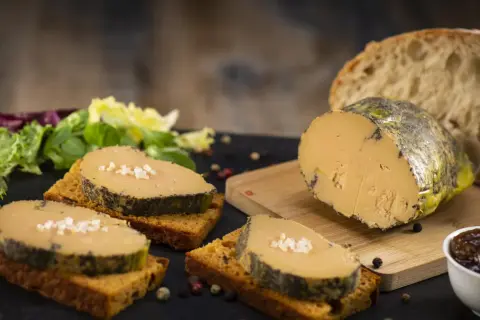 Tranches de foie gras sur toasts, accompagnées de salade verte, pain frais et confiture. La cuisson du foie gras est parfaite.