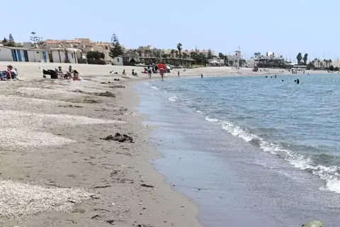 Gente disfrutando de un día soleado en la playa de Almerimar. Las opiniones sobre este lugar son muy positivas, ideal para relajarse.