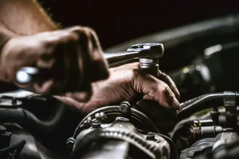 Mechaniker repariert Auto. Die anlasser wechseln kosten sind hier im Fokus.