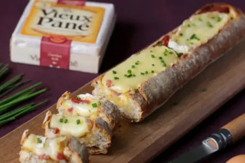 Un pain garni de fromage fondant et de lardons, parfait pour un apéro dinatoire.