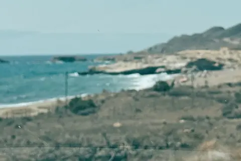 Vista de la playa de los Genoveses, con el mar azul y las colinas. Un lugar ideal para disfrutar y comer algo.