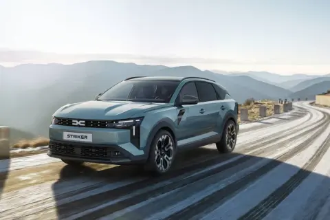 Nowy Dacia c neo STRIKER przemierza krętą, ośnieżoną drogę w górach.