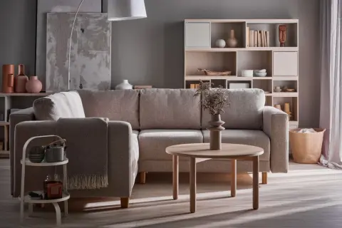 Przytulny salon z szarą kanapą i beżowymi dodatkami. Czy szary pasuje do beżu? Zdecydowanie tak, tworząc harmonijną całość.