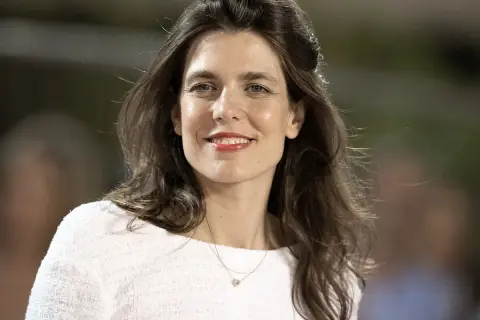Charlotte Casiraghi sonríe con un collar delicado y un suéter blanco.