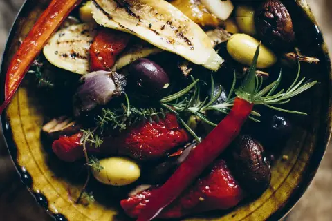 En skål med grillade grönsaker, oliver och chili. Perfekt som antipasti recept.