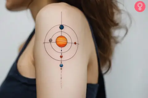 Tatuajes del sistema solar en el hombro, con el sol naranja en el centro y planetas coloridos orbitando.