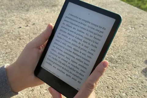 Une personne lit un livre sur une liseuse Kindle. Apprenez comment prêter un livre Kindle à un ami.