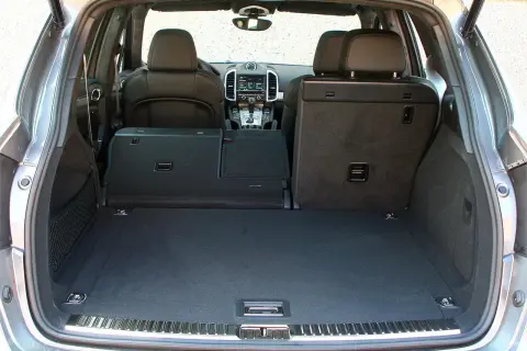 Maletero de un Porsche Cayenne, mostrando su amplitud y los asientos traseros abatibles. Ideal para conocer las porsche cayenne medidas de carga.