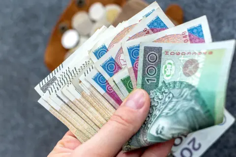 Dłoń trzyma plik polskich banknotów. Zastanawiasz się, ile wynosi podatek od renty?