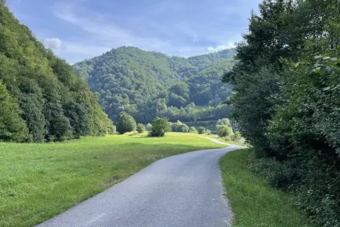 Droga wije się przez zieloną dolinę, otoczoną lasami. Idealne miejsce na przejażdżkę **velo Poprad**.