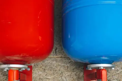 Deux réservoirs, un rouge et un bleu, sont montés sur des supports. Ils semblent prêts à gérer le gonfler vase expansion.