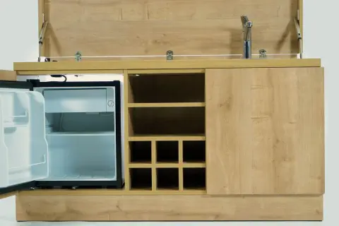 Hotelowy minibar z otwartą lodówką i miejscem na butelki. Zastanawiasz się, czy za minibar w hotelu się płaci?