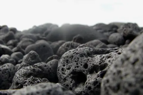 Pietre laviche porose su una spiaggia. Scopri come pulire la pietra lavica per mantenerla al meglio.