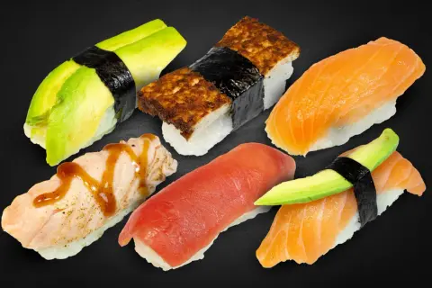 Sechs Nigiri-Sushi-Stücke: Lachs, Thunfisch, Avocado und Tamagoyaki. Was ist Nigiri? Sushi mit Reis und Belag, oft mit Nori umwickelt.