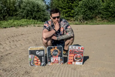 Mężczyzna w hawajskiej koszuli prezentuje trzy grille jednorazowe, gotowe na piknik.