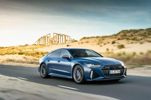 Niebieskie Audi RS7 pędzi po pustynnej drodze. Sprawdź aktualną audi rs7 cena i poczuj moc!