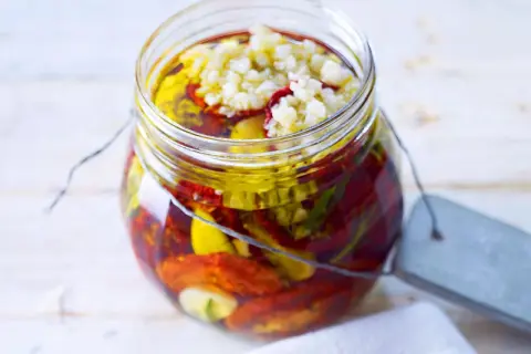 Glas mit getrockneten Tomaten, Knoblauch und Kräutern in Öl. Perfekt zum getrocknete tomaten einlegen.