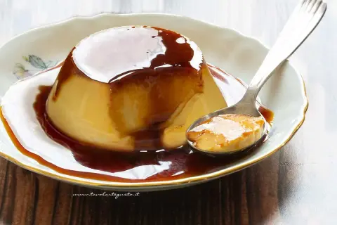 Delizioso creme caramel su un piatto bianco, con una cucchiaiata pronta da gustare.