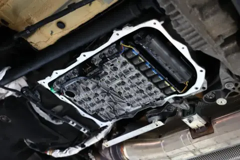 Widok od spodu na otwartą skrzynię biegów Forda PowerShift z widocznymi elementami hydraulicznymi i elektrycznymi.