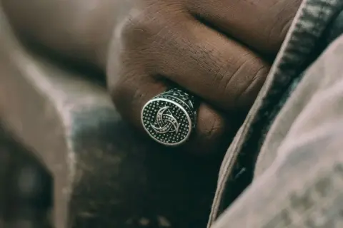 Męska dłoń z sygnetem w kształcie potrójnego rogu Odyna. Co to za symbol?