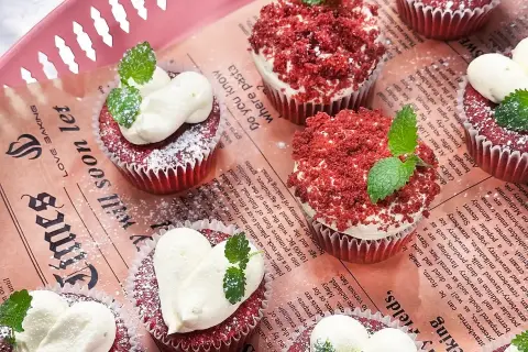 Red velvet muffins med fluffig frosting och myntablad. En härlig syn av röda sammetsmuffins!