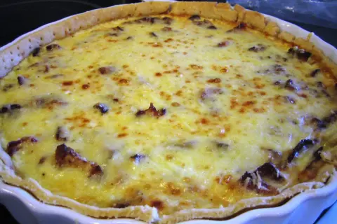 En gyllene kantarellpaj med bacon, perfekt för en höstig middag.