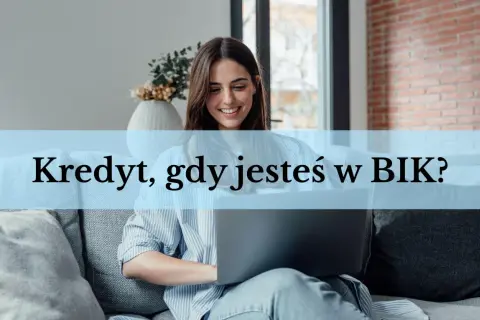 Uśmiechnięta kobieta z laptopem na kanapie.