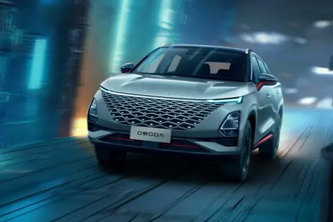 Nowoczesny SUV OMODA pędzi nocą przez futurystyczne miasto. Omoda co to za marka? To styl i innowacja.
