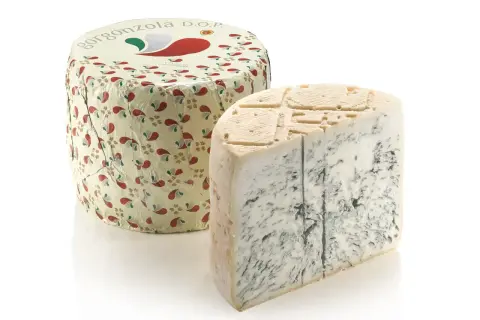 Kawałek sera gorgonzola DOP z widocznymi niebieskimi żyłkami, obok okrągłego opakowania z motywem paisley.