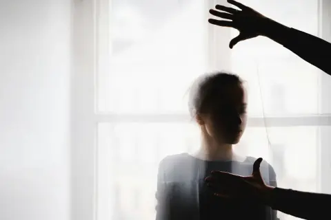Cień dłoni nad głową i na piersi kobiety, symbolizujący moment, kiedy manipulant odpuszcza.