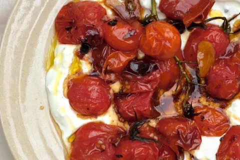 Geröstete Kirschtomaten auf cremigem Feta-Dip, beträufelt mit Olivenöl. Ein köstlicher Tomaten Feta Dip.