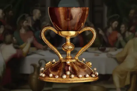 El cáliz dorado, adornado con perlas y gemas, evoca la búsqueda del santo grial donde está. Detrás, la Última Cena.