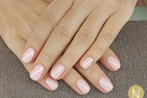 Mani curate con unghie corte e smalto rosa pastello. La forma unghie corte è elegante e pratica, perfetta per ogni occasione.