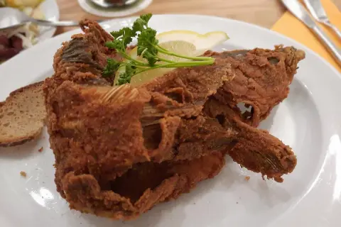 Knusprig panierter Karpfen, garniert mit Zitrone und Petersilie, serviert mit Brot. Ein Fest für Genießer – der beste Karpfen Frankens!