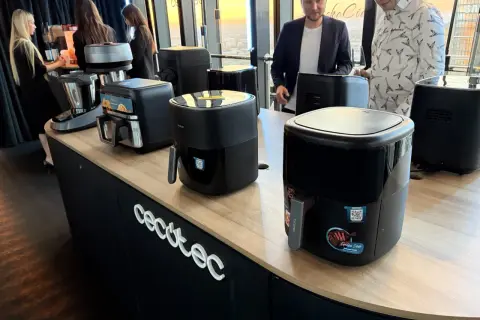 Prezentacja urządzeń kuchennych marki Cecotec. Na ladzie stoją frytkownice beztłuszczowe i robot kuchenny.