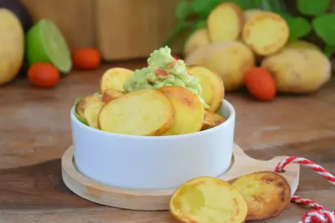 Selbstgemachte Kartoffelchips mit Guacamole, ein leckerer Snack.