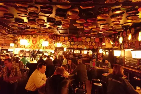 Interno di un locale a Bruxelles, con il soffitto e le pareti ricoperti di tappi e dischi di latta. Un'atmosfera da vero delirium.
