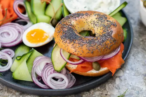 En bagel med lax, färskost, rödlök, gurka och kapris. Ett perfekt brunch recept för en lyxig start på dagen.