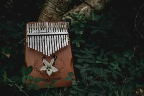 Drewniana kalimba z metalowymi klawiszami, ozdobiona motywem jelenia i kwiatu. To instrument, który zachwyca dźwiękiem.