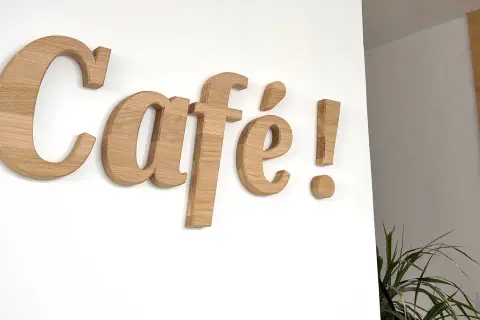Une belle lettre en bois "Café !" orne le mur blanc, invitant à la détente.